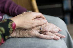 holding elderly resident's hand